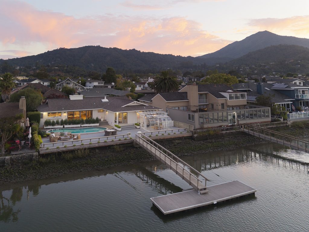 A twilight image of a house in Larkspur on the San Francisco Bay with Mt. Tamalpais in the background and a vibrant, red sunset.