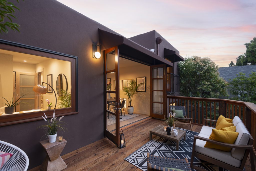 An upper deck on a home with glowing windows at twilight.